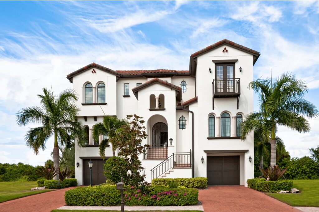 A tall, white Florida home with a tropical feel that is in pristine condition after receiving a brand new roof.